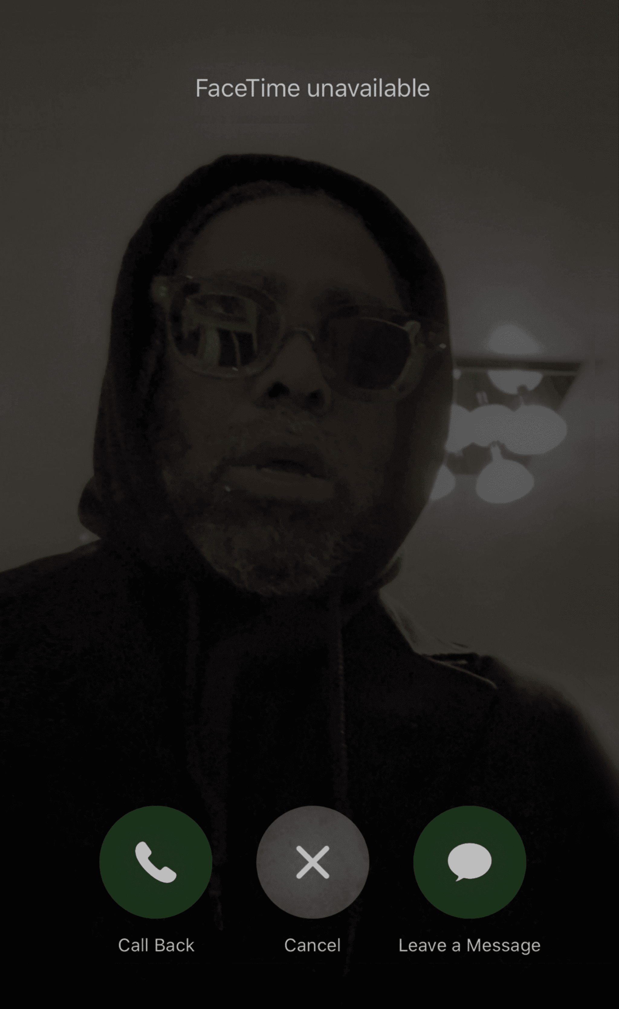 Arthur Jafa looks on in sunglasses and a black hoodie in a photo that looks like a screenshot from an iPhone. At the top it says "Facetime unavailable" and at the bottom are the familiar buttons for "Call back" "Cancel" and "Leave a Message".