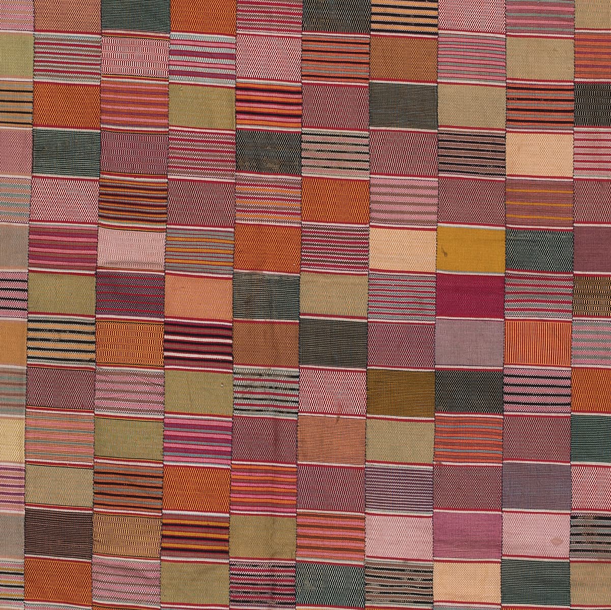 Ewe cotton chief's cloth, ca. 1930-1950. Many different colors are patched together, some with multiple lines visible in them and others more solid.