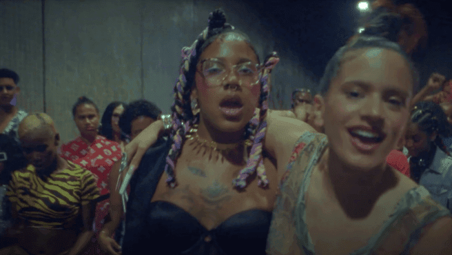 Still from music video Linda by Tokischa and Rosalia, shows the two singing to the camera, hands around each other's shoulders.