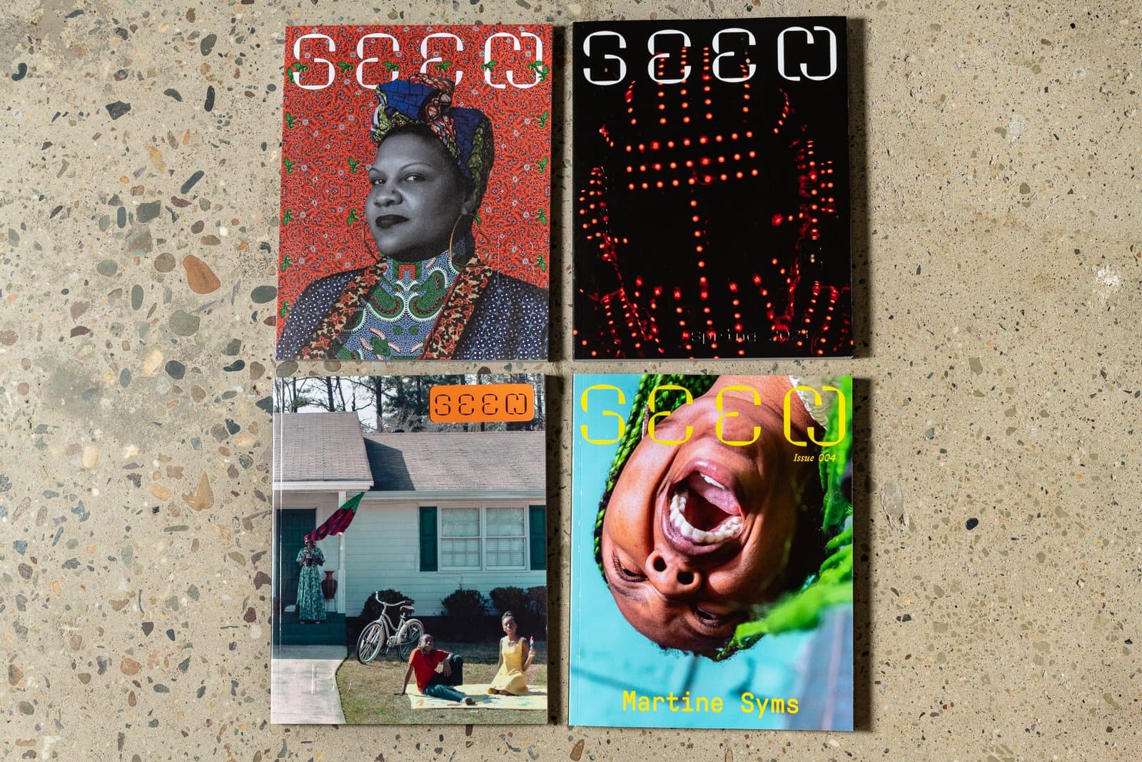 Four issues of Seen laid out in a square on the floor