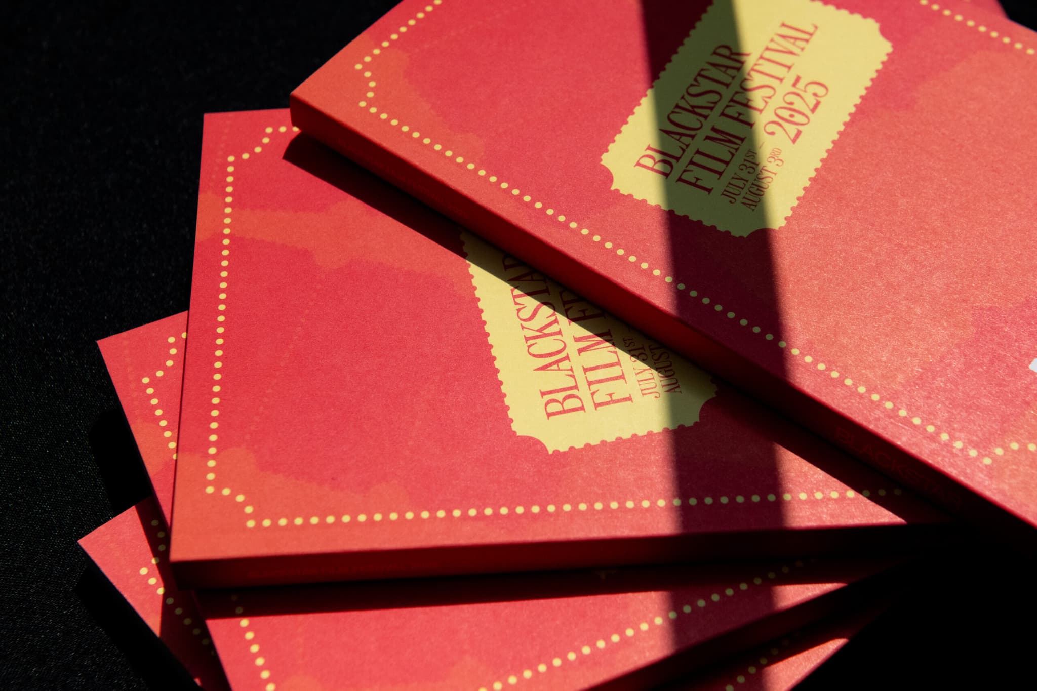 BlackStar Film Festival 2025 program guides stacked on table.