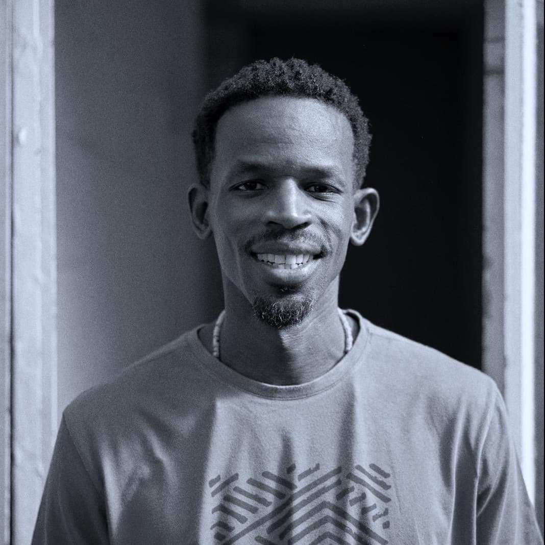 A photograph shows a black and white portrait of Wally Fall standing outside.