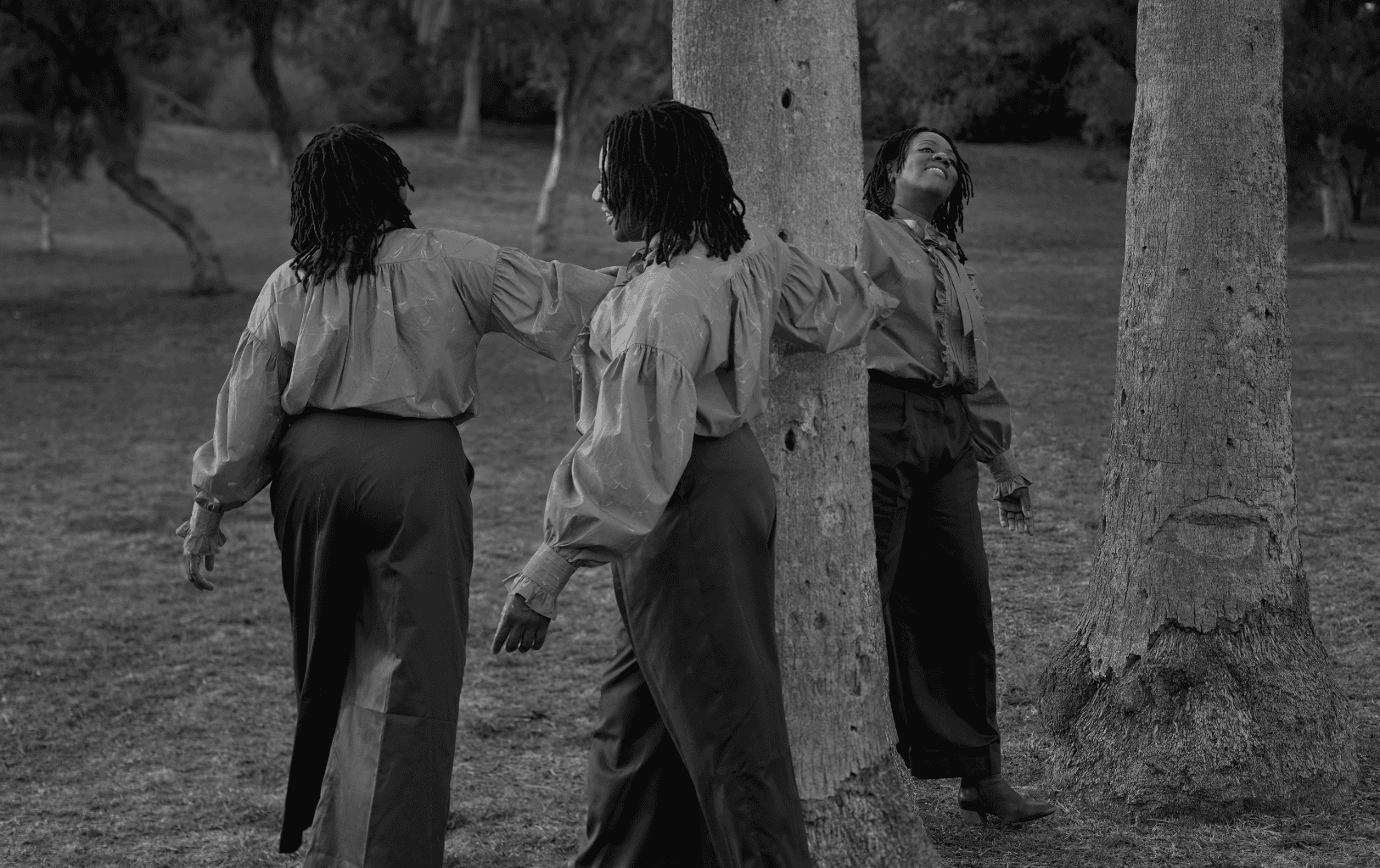 A photo of Cauleen Smith, digitally altered to make it appear as if there are three Cauleens, all circling a tree.