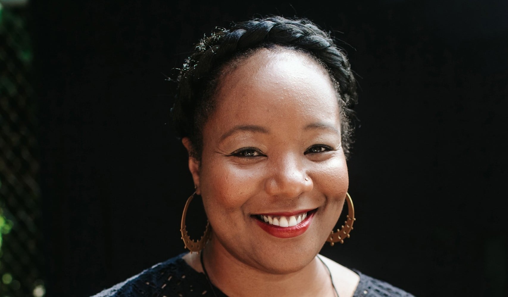 A headshot of Maori Karmael Holmes. She is smiling and looking at the camera.