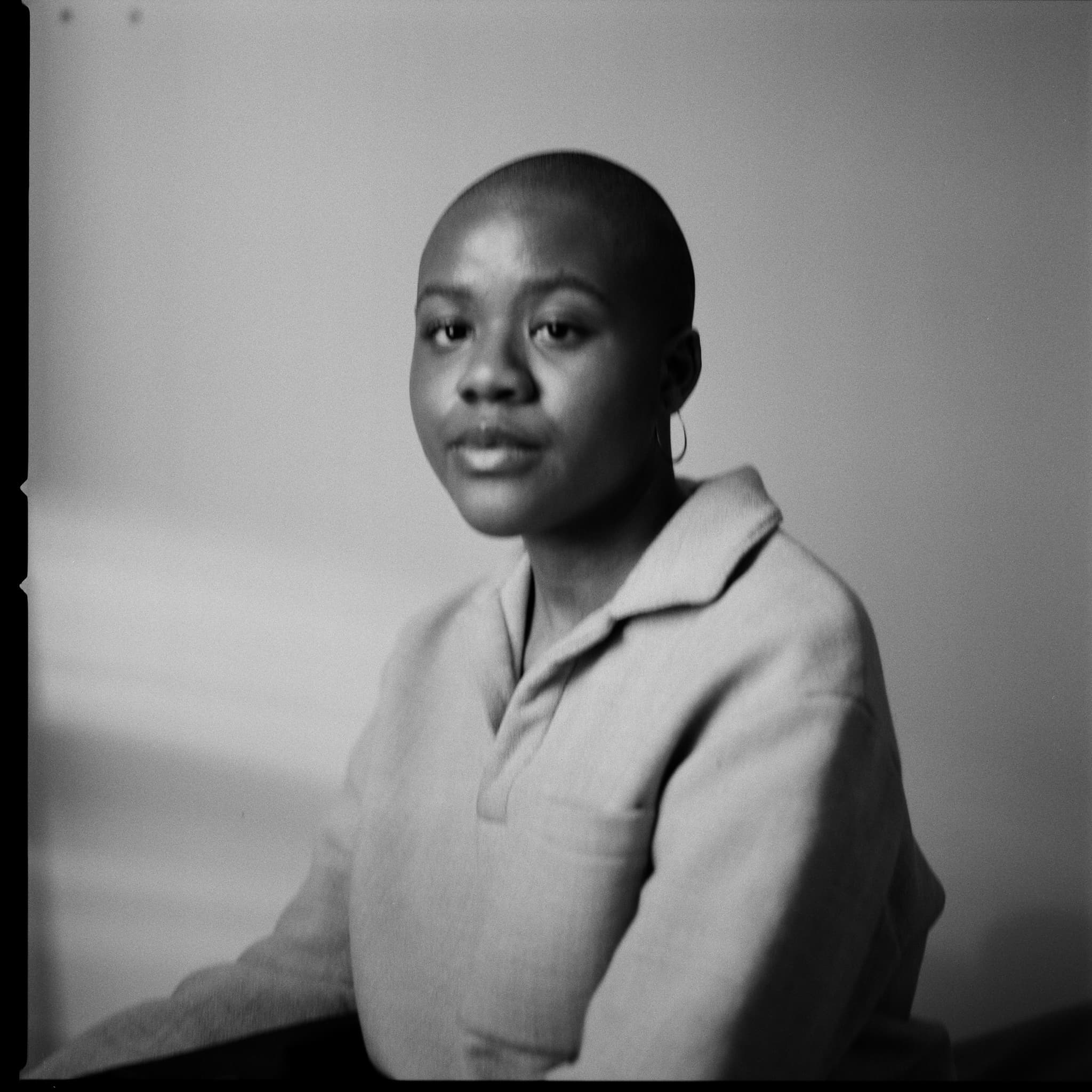 A photograph shows a black and white portrait of Devon Blackwell sitting with her head slightly turned towards the camera.