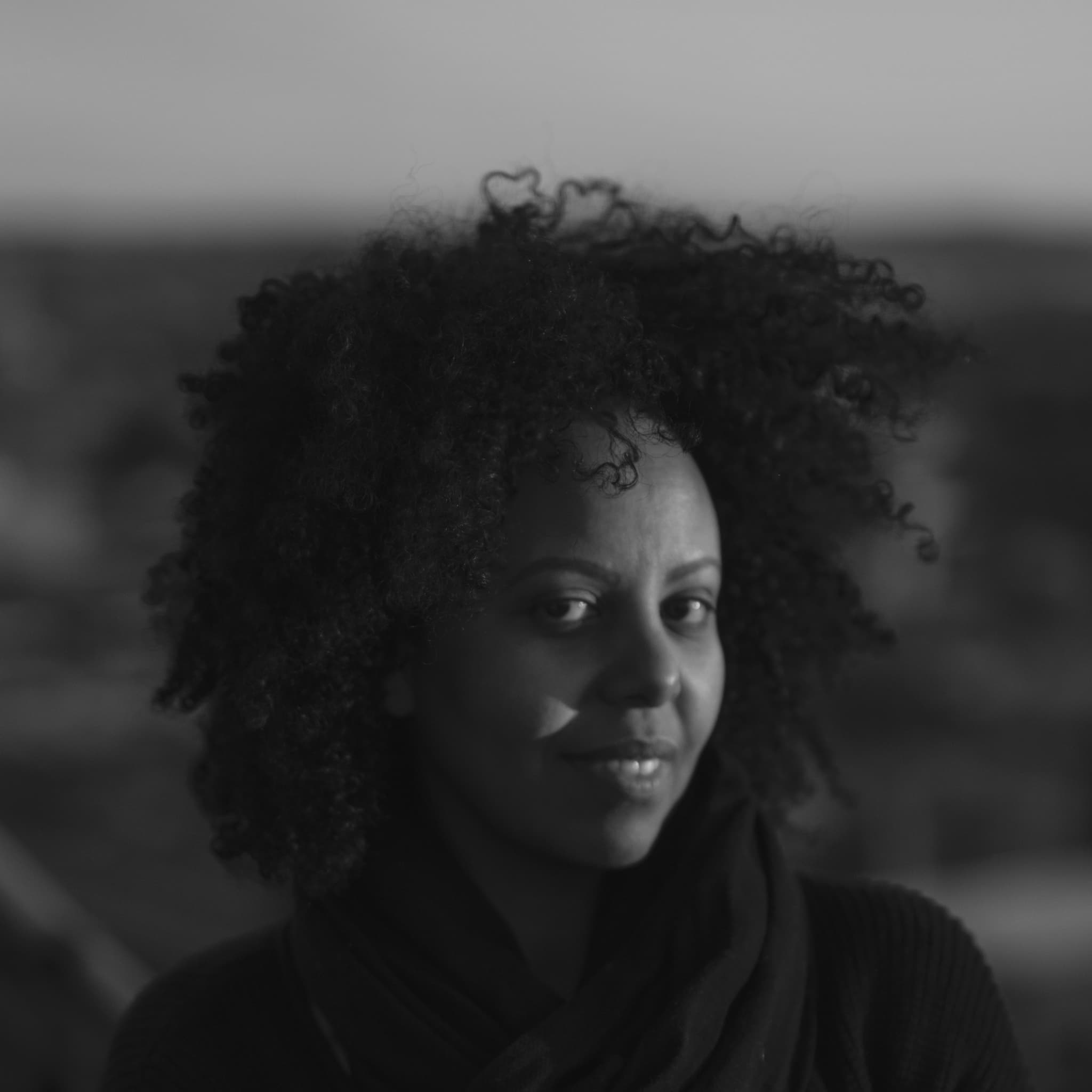 A photograph shows a black and white portrait of Nazenet Habtezghi outside.