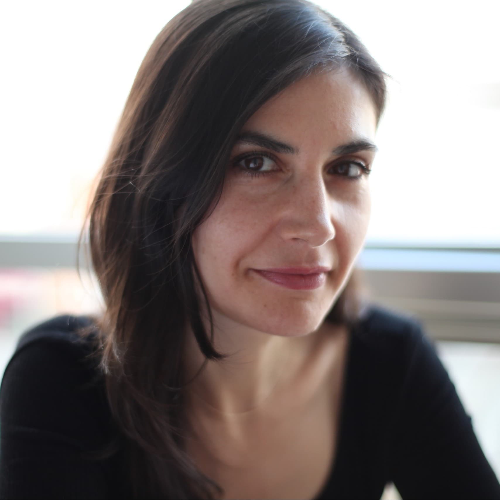A photograph shows a headshot of Alexis Neophytides looking at the camera.