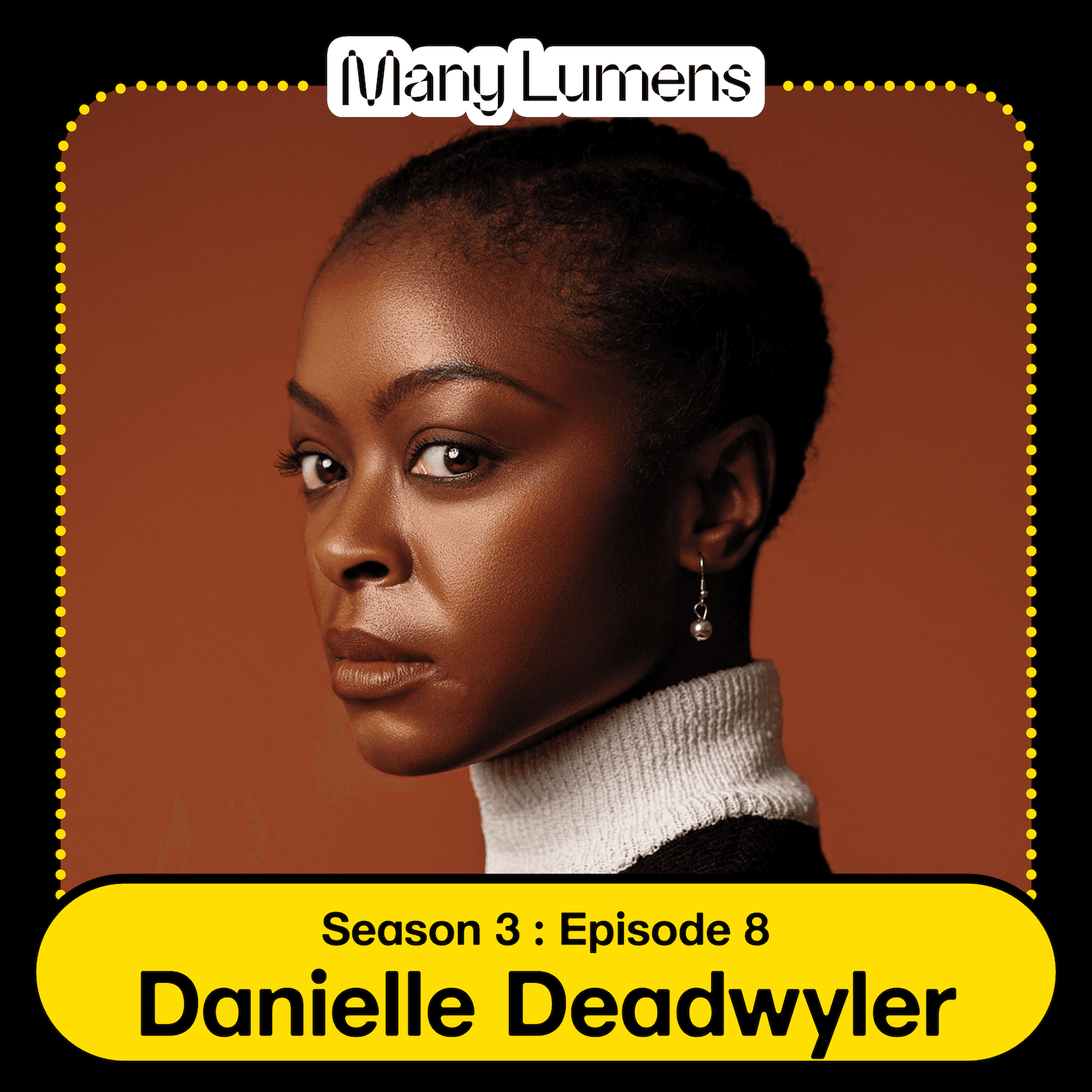 A headshot of Danielle Deadwyler. She is a Black woman with short black hair, it is braided into an updo. She is posed in front of a burgundy background. She has a serious expression and is looking intently into the camera.