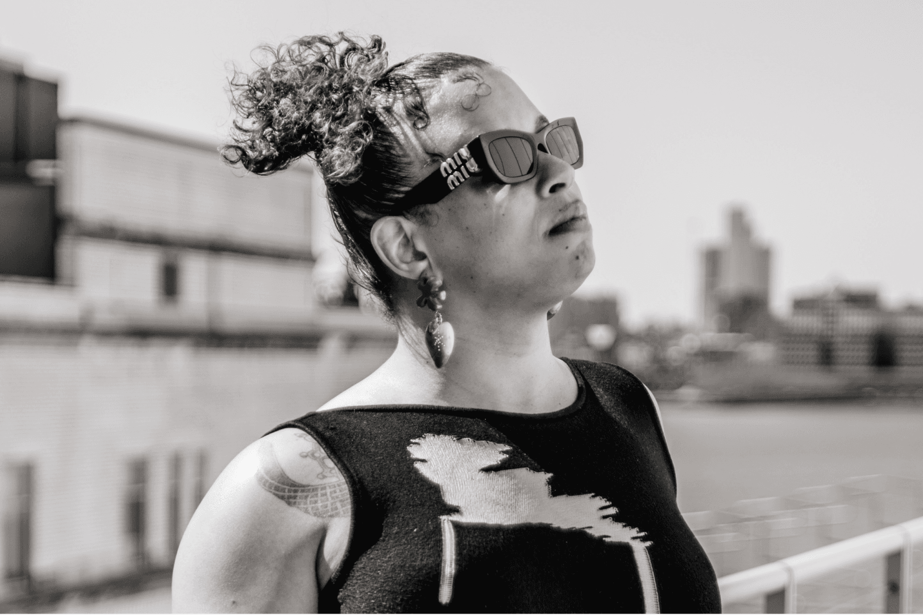 A photo of Tourmaline, wearing sunglasses and looking up at the sky.