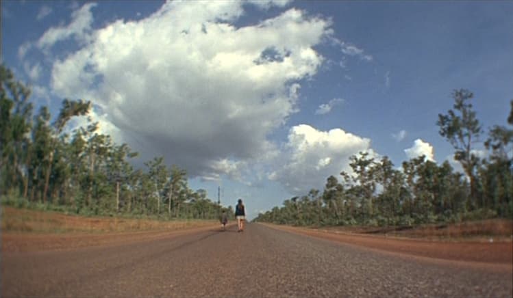 A wide shot image of big white clouds hovering over a dusty desert landscape