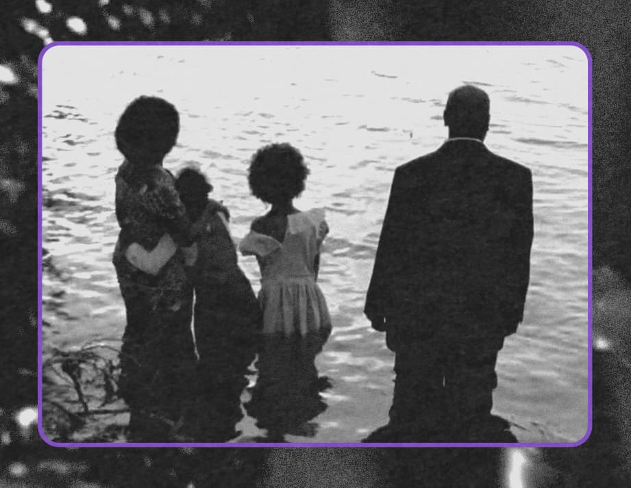 A still from Boneshaker, a family of four standing in shallow water. One of the daughters clings to the mother, while the other stands beside them with the father.