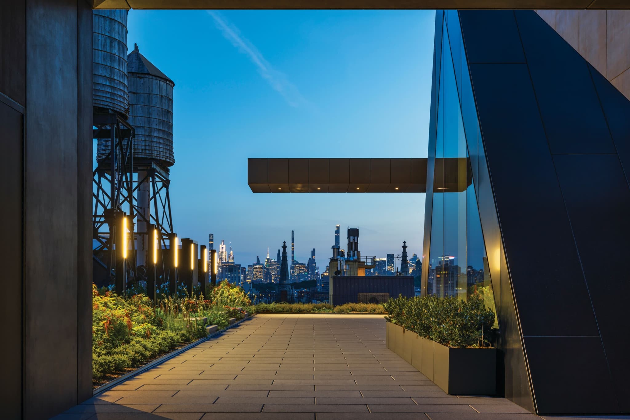 View from the rooftop terrace at the Studio Museum in Harlem, with the city skyline visible and plants along the walkway.