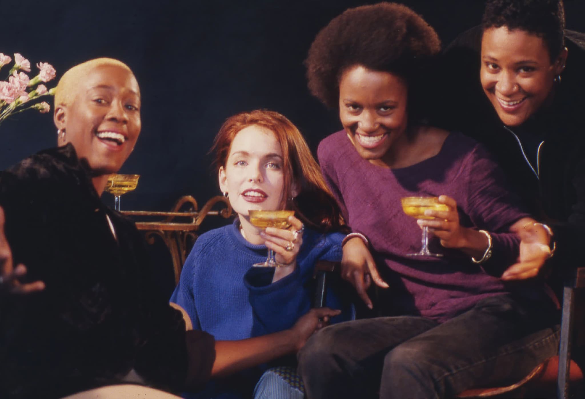 The cast of The Watermelon Woman poses for a photo, Cheryl is sitting to the left, and two of the cast members are holding drinks in their hands.