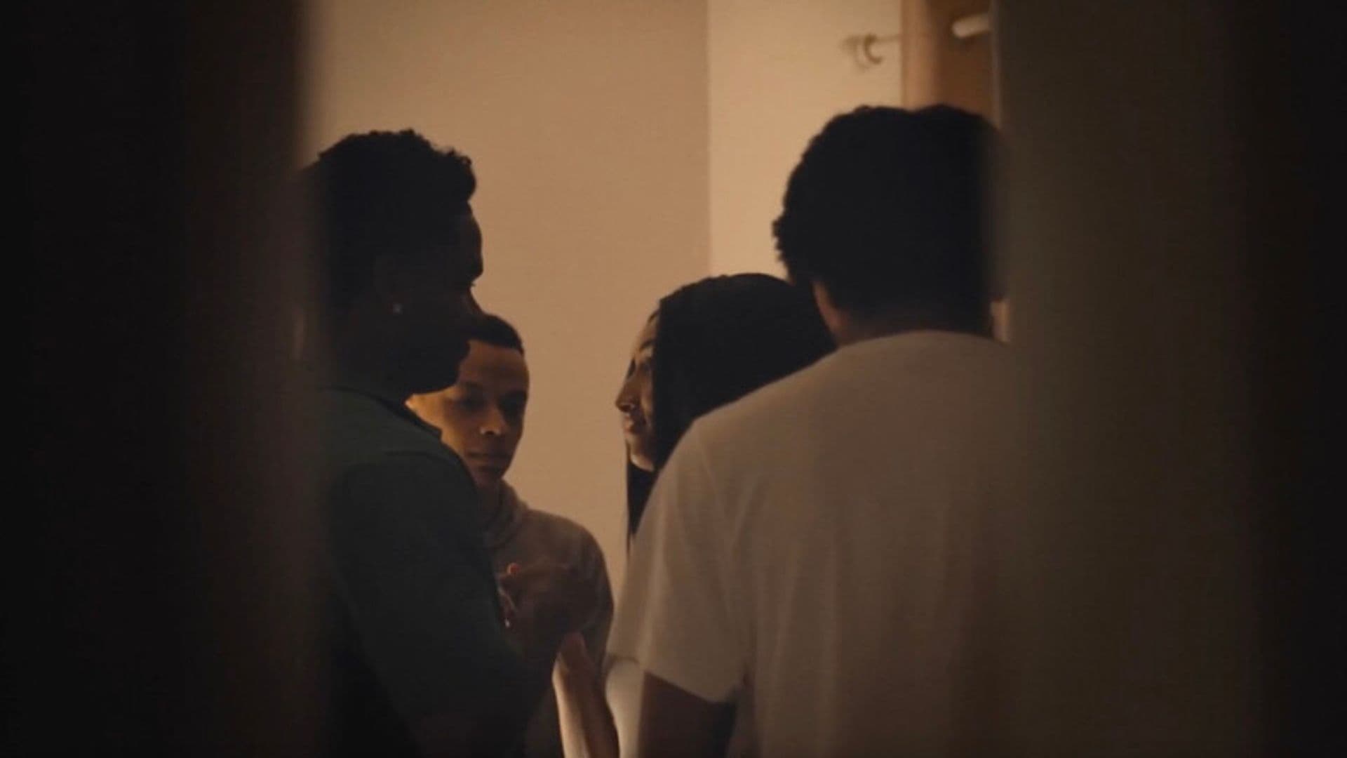 A film still from Free Lyric shows a teenage Black girl surrounded by three teenage Black boys in a room.