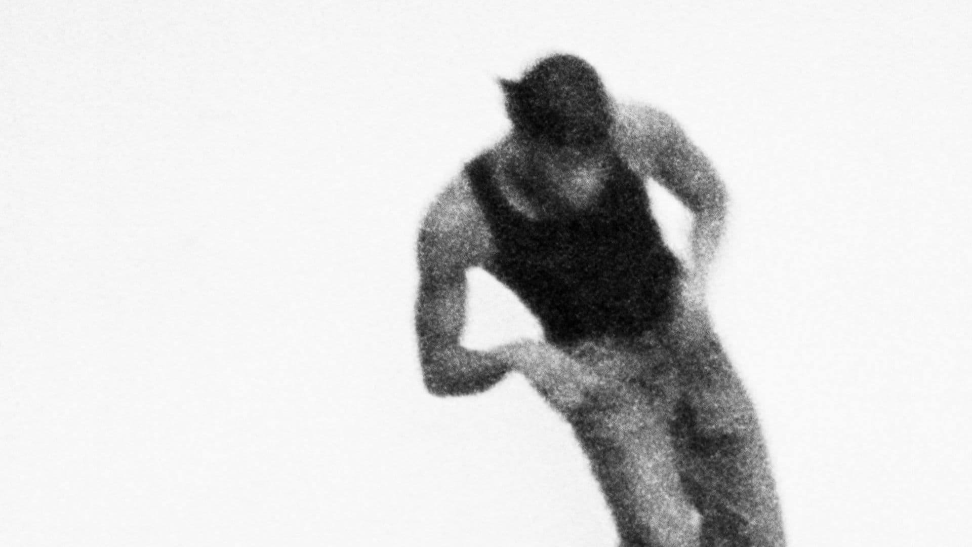 A black-and-white film still from Revival 24 shows a blurred figure of a Black man dancing mid-motion against a black background. The man is wearing a black tank top, jeans, and a dark-colored durag.