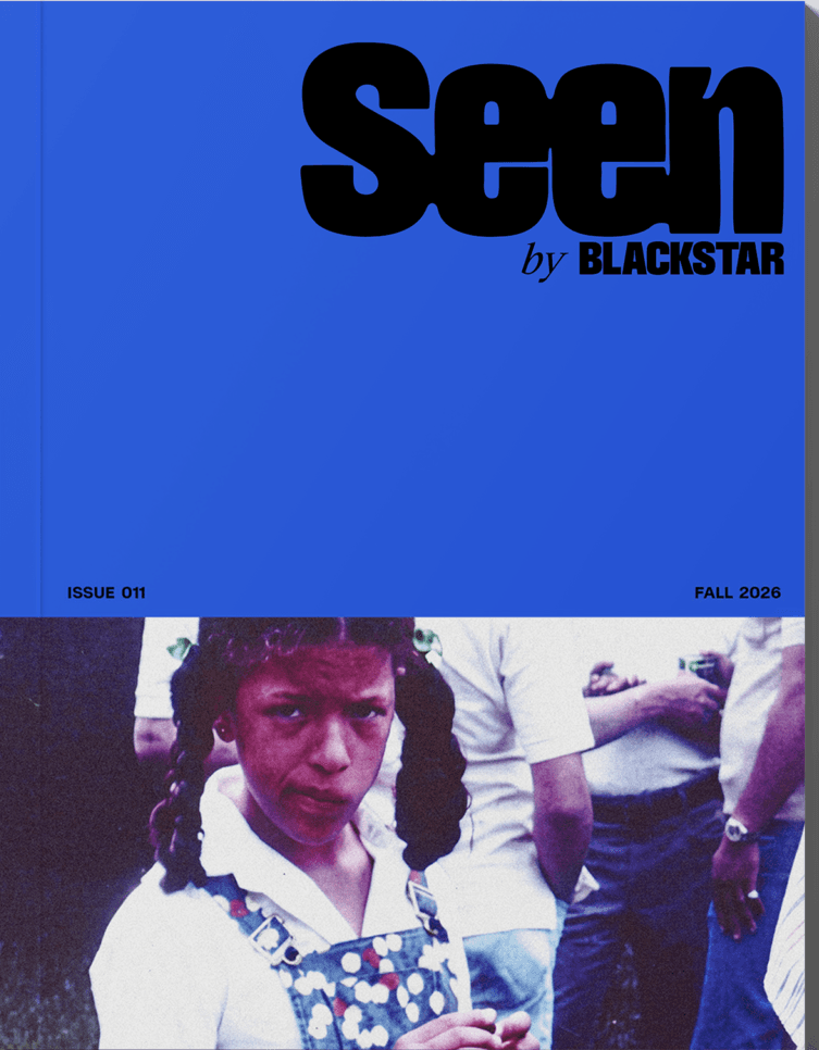 An image of the Seen Issue 011 cover. The top half of it is cobalt blue with the Seen logo in the upper right corner. The bottom half has a photo of Michele Stephenson as a young girl. She is wearing denim overalls with polkadots over a white button down shirt. She has pig tails and a smirk on her face.